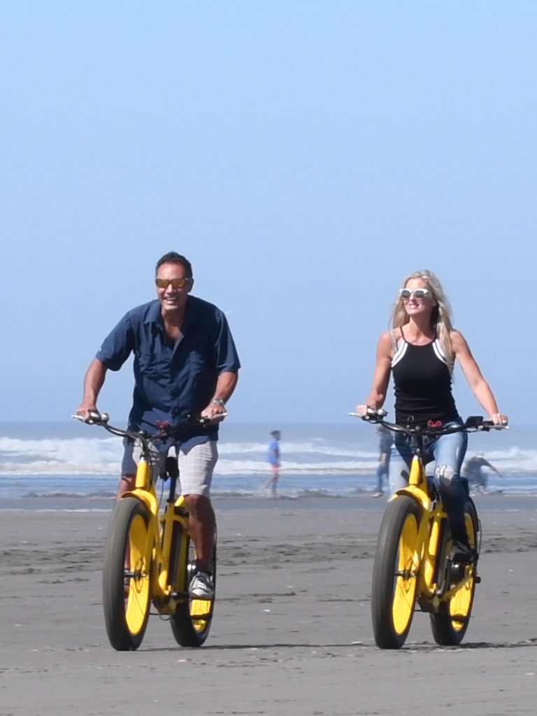 A couple rides bikes on the beach near Seabrook