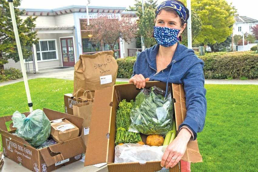 A woman hold a box of produce at the Port Townsend Farmers Market