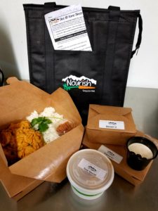 A group of takeout food and a black bag