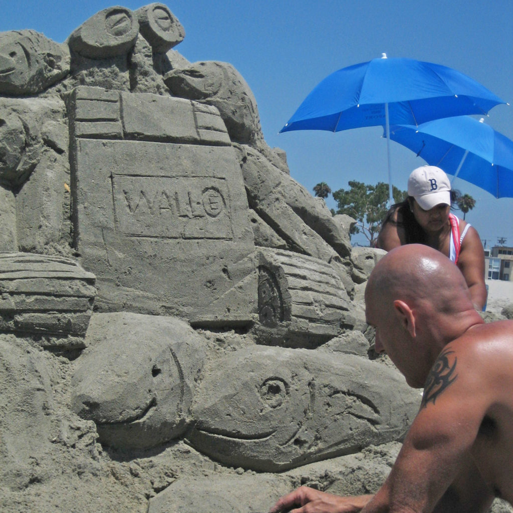 Douglas Orr finalizing the base of his "Wall-E" sandcastle sculpture
