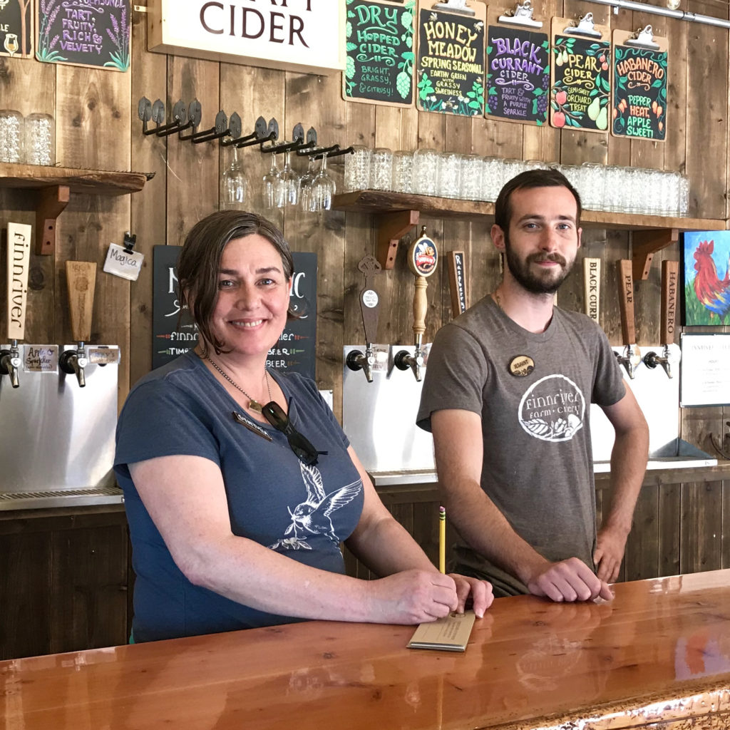 Two people standing at the cider bar