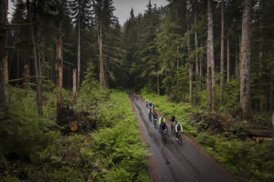 Bicyclists on a wooded road Sol Grinder Race