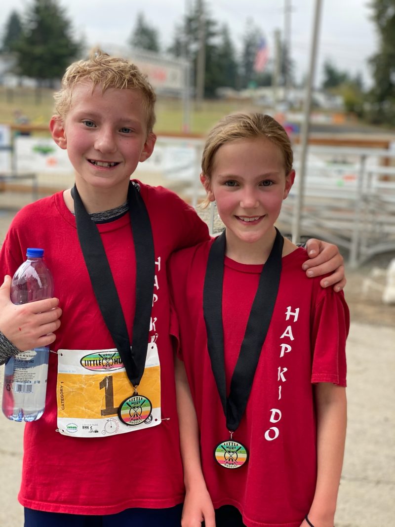 Two kids wearing race medals