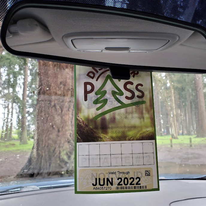 Washington State Discover Pass hanging in a rearview car mirror