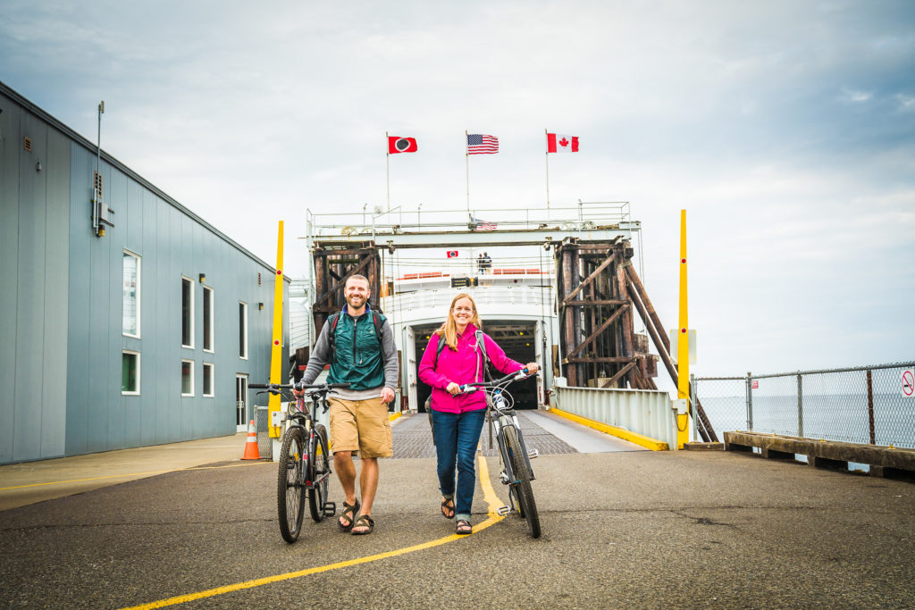A couple with bikes walks off a ferry