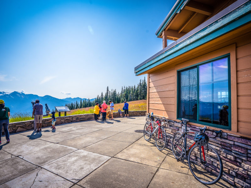 Bicycles line the Hurricane Ridge Visitor Center as people look at the mountains.