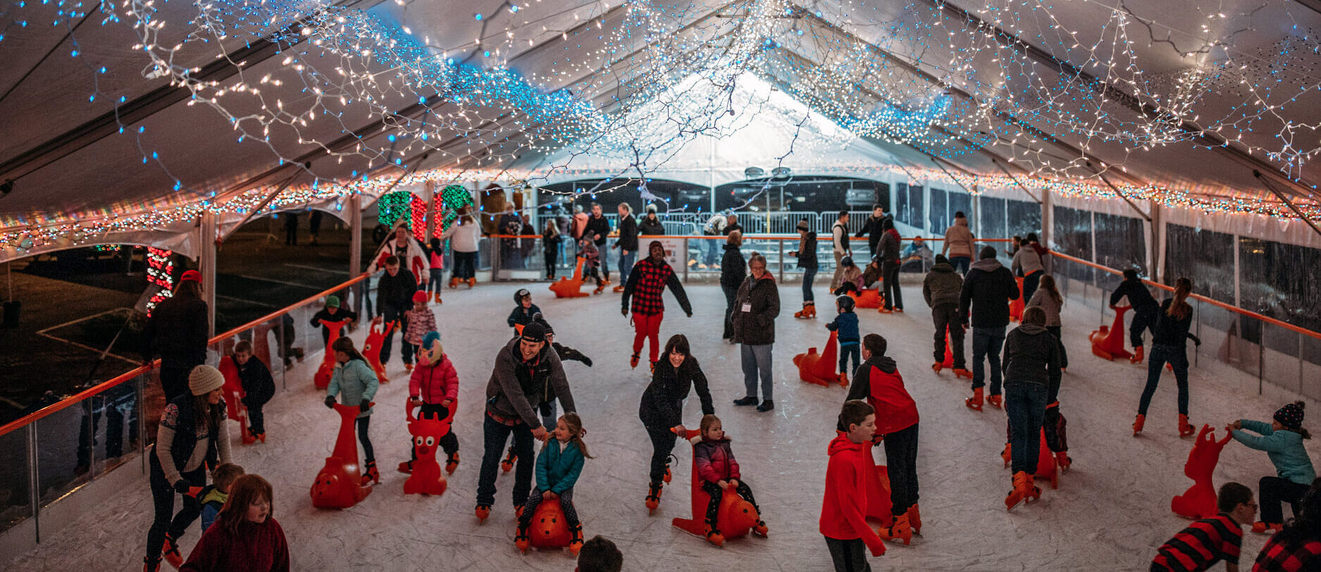 Photo of many ice skaters enjoying the Port Angeles Winter Ice Village that is lit up with holiday lights - Delight in the Holiday Lights on the Olympic Peninsula, WA