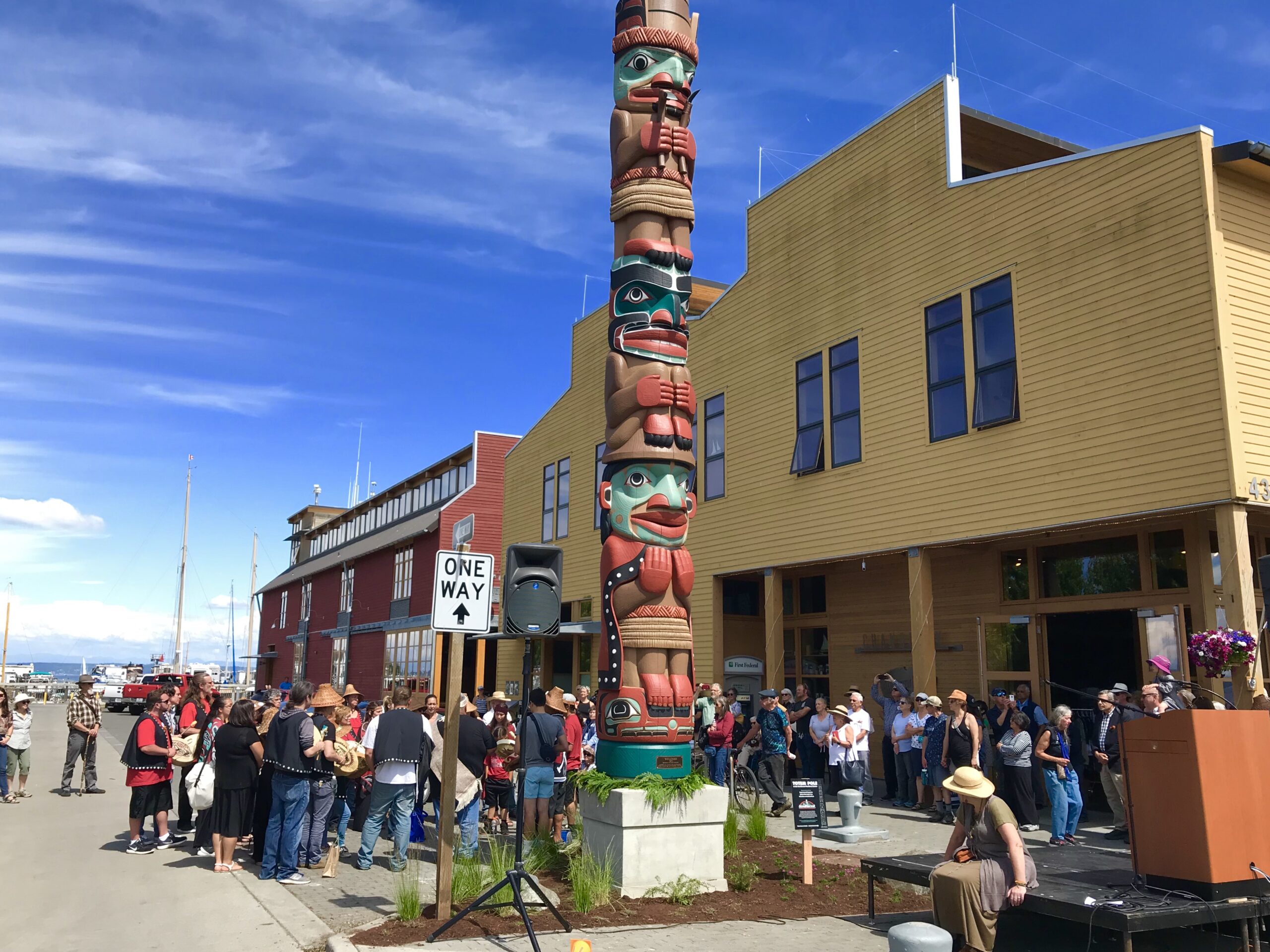 Photo of people celebrating the installation of the new totem pole at the NW Maritime Center while they experience the best of maritime Port Townsend, WA.