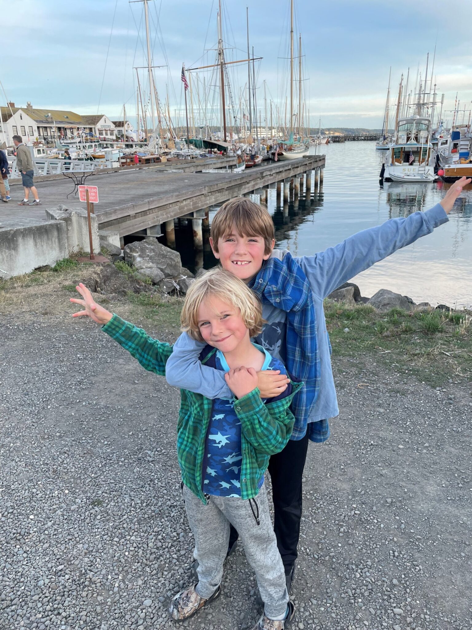 photo of two children posing for a picture in front of Point Hudson Marina while they experience the best of maritime Port Townsend
