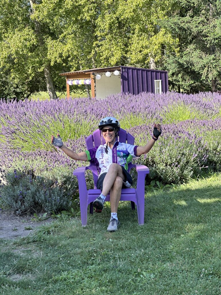 Tour de Lavender participant sitting amongst lavender - Bicycling Adventures Through the Sequim-Dungeness Valley