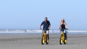 Couples Ride Bicyles on the beach in Ocean Shores