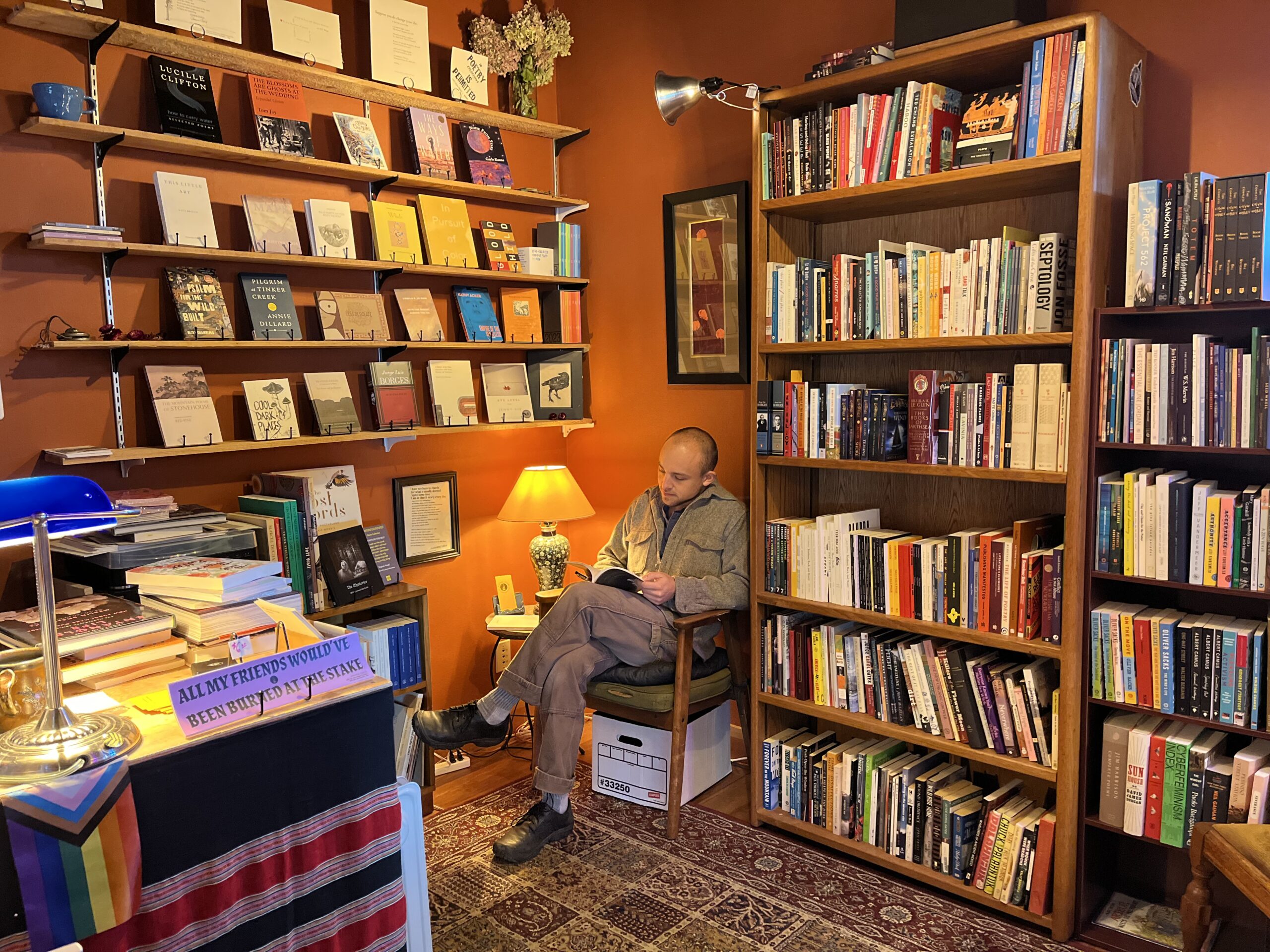Photo of 2025-2026 City Poet Laureate Conner Bouchard-Roberts in his bookshop, Winter Texts in Port Townsend, WA