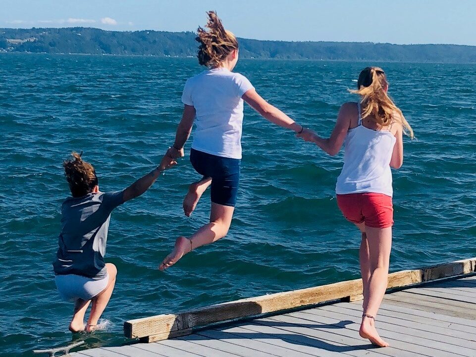 Photo of three young children jumping off the dock somewhere on the Hood Canal in Washington state