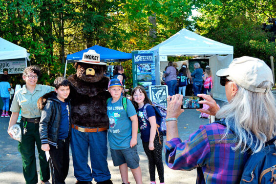 photo of Smokey bear and a family taking a photo together at the Dungeness River Festival on the Olympic Peninsula near Sequim, WA