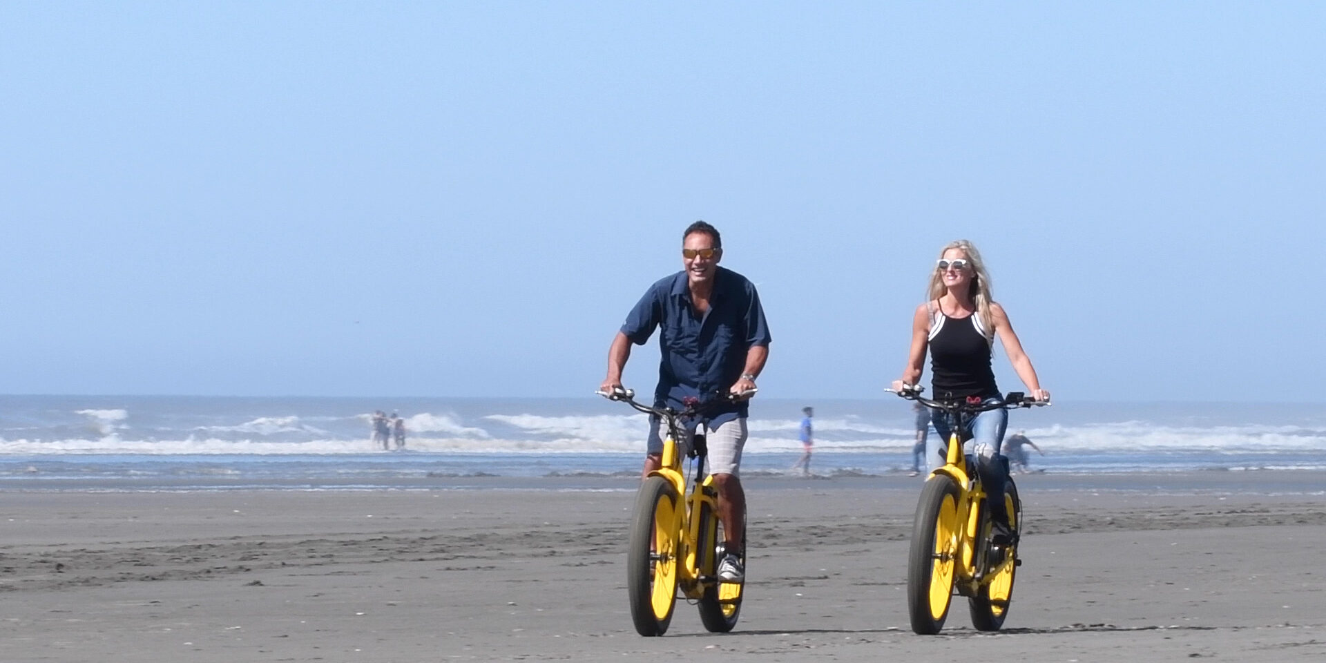 Couples Ride Bicyles on the beach in Ocean Shores