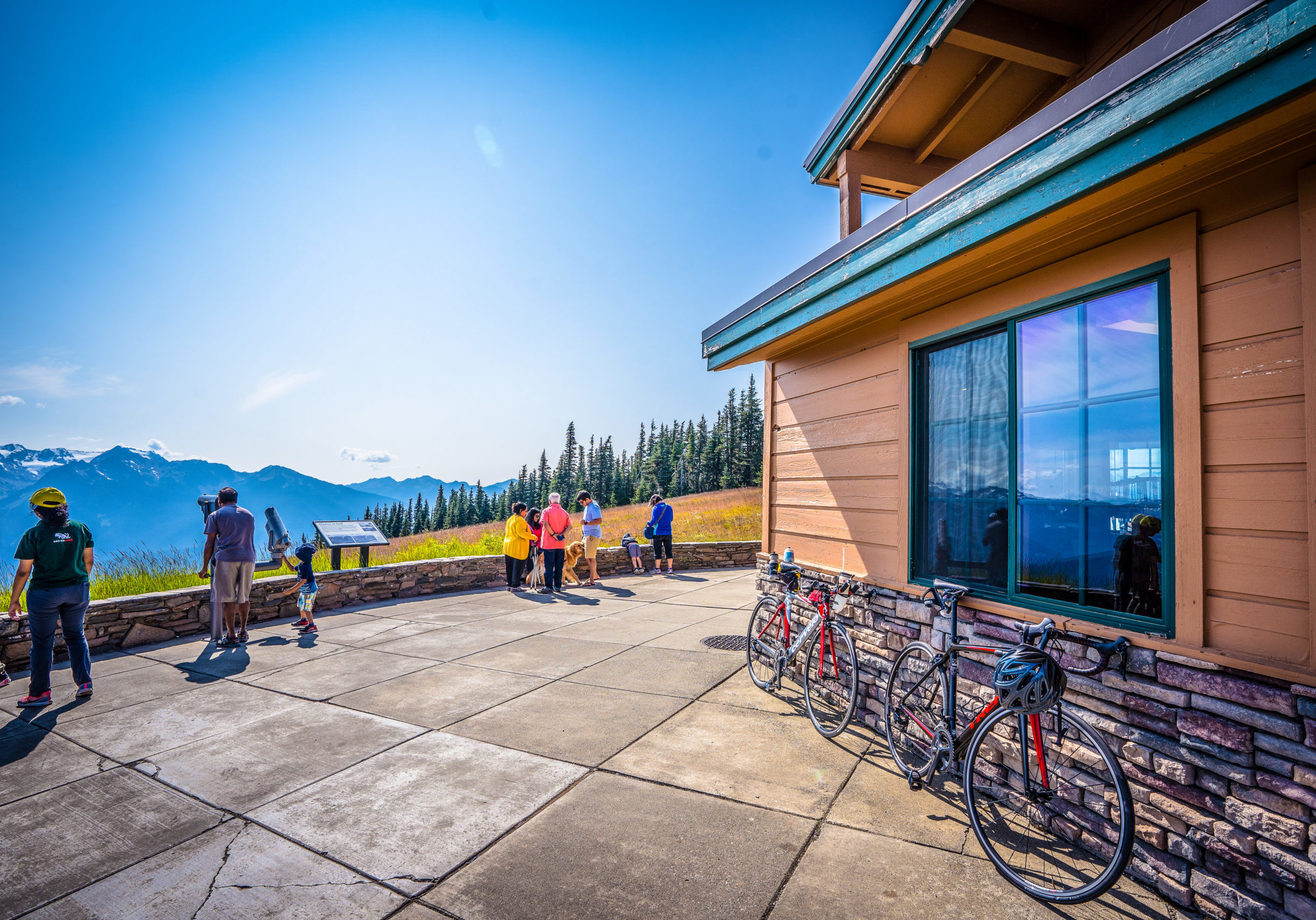 Bicycles line the Hurricane Ridge Visitor Center as people look at the mountains.